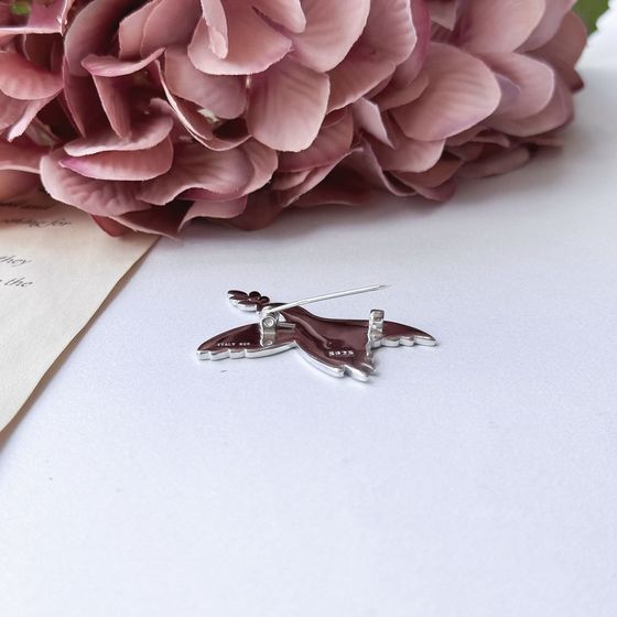 A silver brooch with semallu